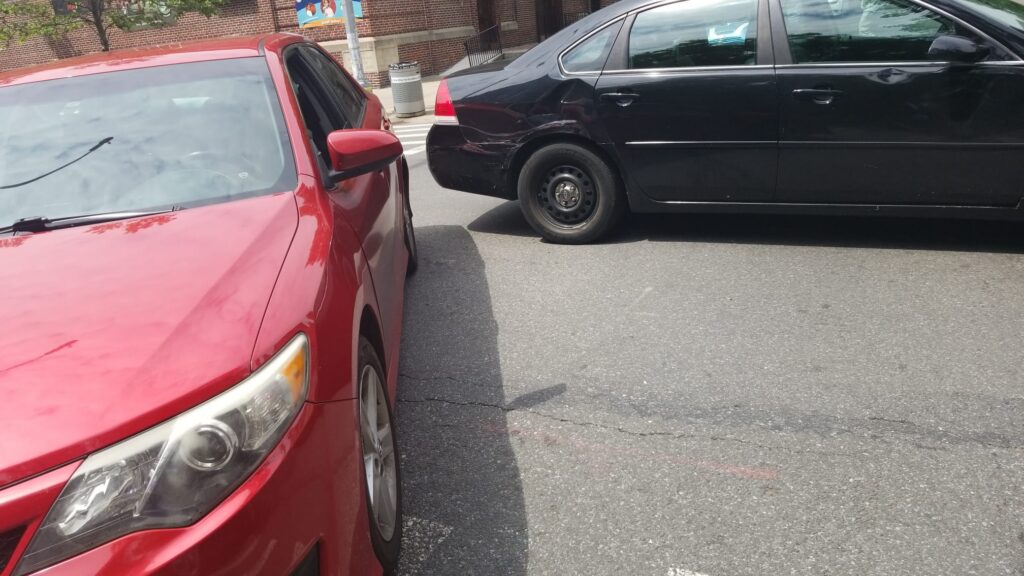 Car with a dented rear quarter panel after a low-impact crash on a New York street