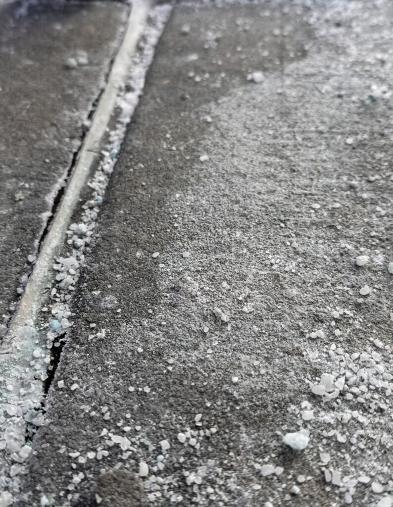 Rock salt scattered on an icy New York sidewalk
