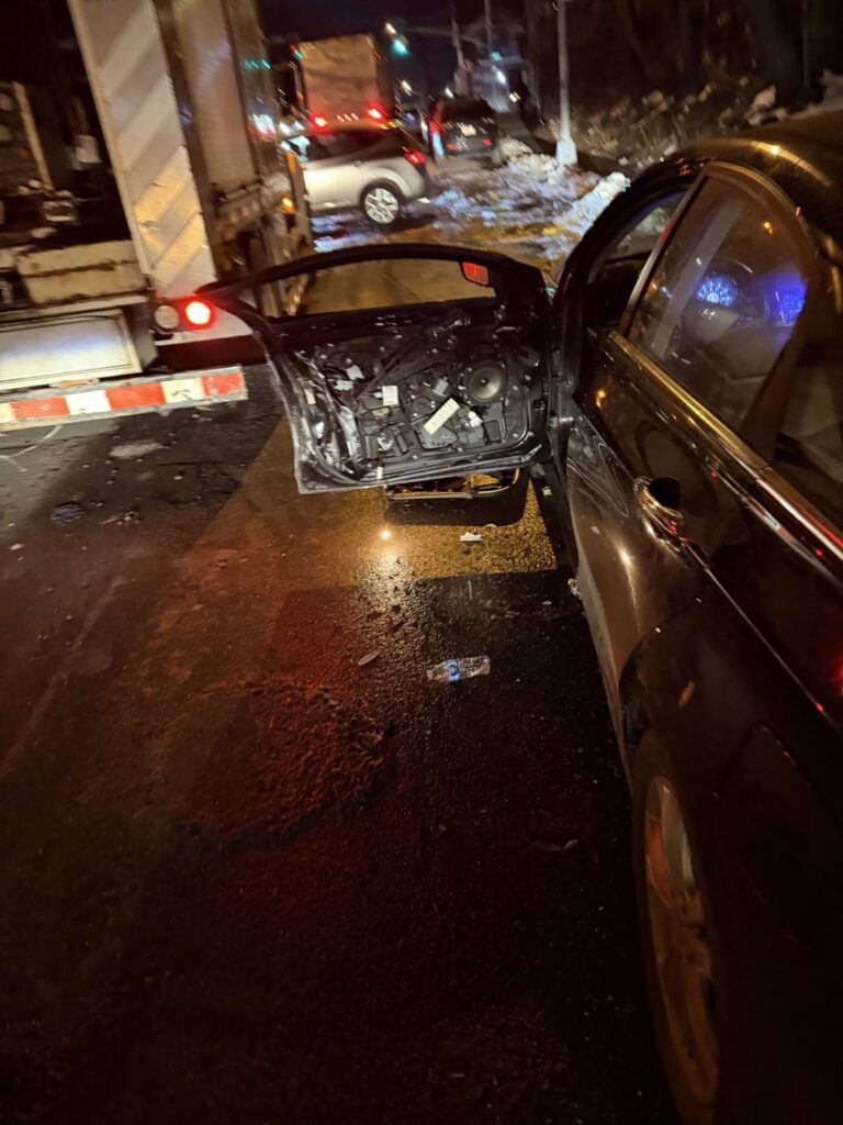 Car with its door torn off after a nighttime crash on a New York street